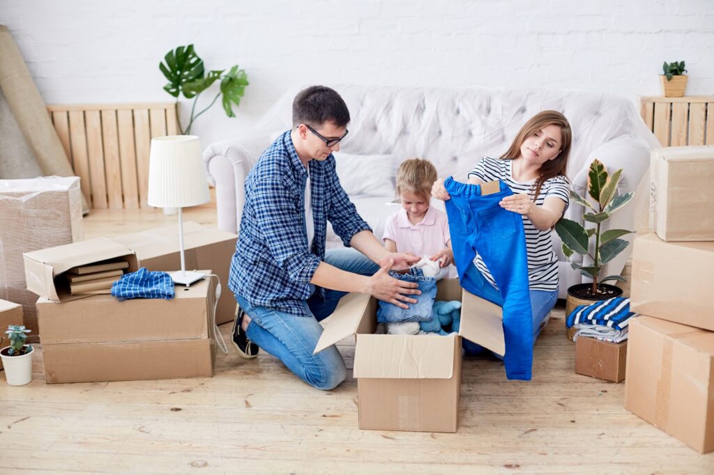 A young family packing clothes for the house move in the concept of 'Balham Removals Cost'.