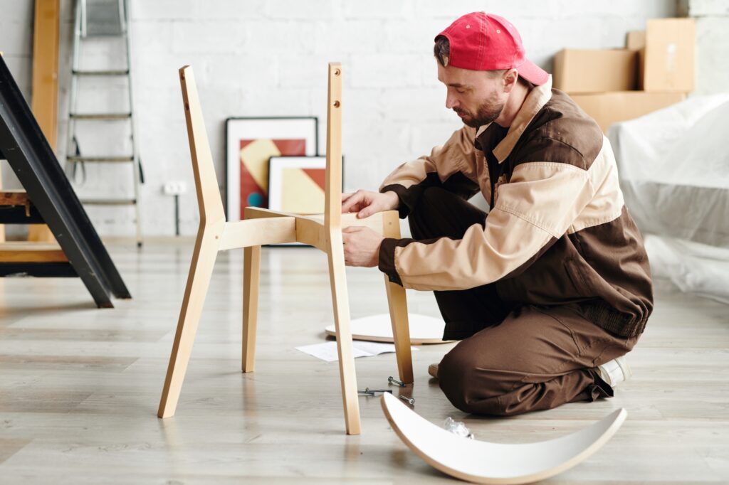 A professional mover reassembling a chair in a new flat